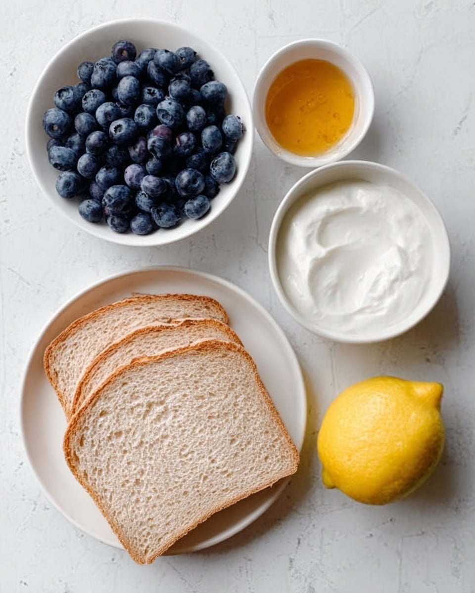 The image shows a white plate with three slices of light brown bread placed side by side at the bottom left. Above the bread, there is a small white bowl filled with fresh, dark blue blueberries. To the right of the bowl, a whole yellow lemon rests on the white marbled surface. Near the lemon, a small white bowl contains golden honey, and next to it, a small white bowl holds white creamy yogurt with a smooth texture. A woman's hand is gently reaching toward the bowl of yogurt. The overall scene is clean and bright with a white marbled texture background, giving a fresh and simple look. photo taken with an iphone --ar 4:5 --v 7