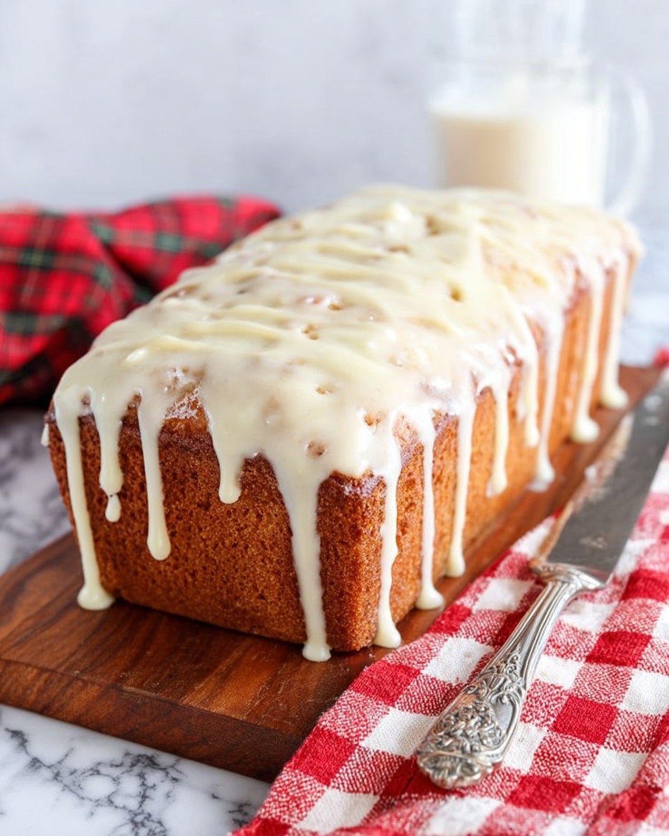 A rectangular loaf cake with a golden-brown surface, covered in a thick layer of creamy white icing that drips down the sides, showing the texture of the cake beneath. The cake sits on a wooden board, next to a metal butter knife with an ornate handle resting on a red and white checkered cloth. The background is a white marbled surface with a blurred glass of milk behind the cake. photo taken with an iphone --ar 4:5 --v 7