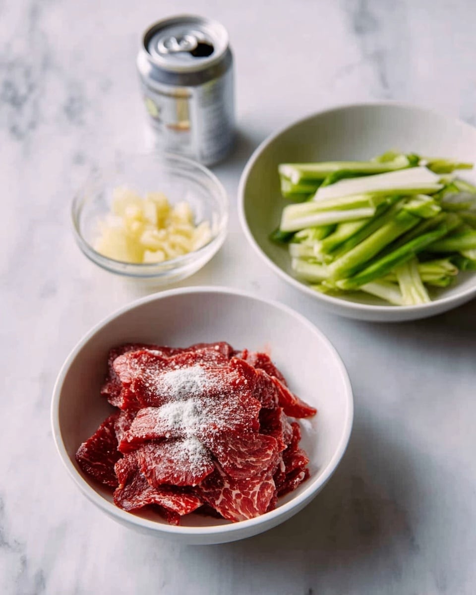 The image shows a white bowl with thin slices of red meat dusted with white powder in the center. Behind it, there is another white bowl filled with green, sliced long vegetables. To the left, a small glass bowl holds a light yellow, chopped ingredient. Next to it, a small aluminum can is placed on a white marbled surface. photo taken with an iphone --ar 4:5 --v 7