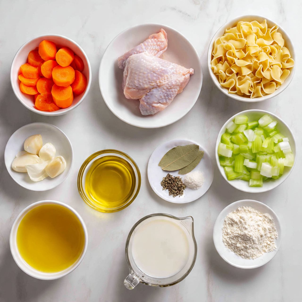 The image shows several ingredients arranged neatly on a white marbled surface. At the center is a white bowl with a whole raw pink chicken piece. Around it, there are seven smaller bowls and containers: one with bright orange carrot slices, one with chopped green celery, one with diced white onions, a small bowl with chopped garlic, a small bowl holding olive oil, a clear glass measuring cup filled with yellow broth, and another clear measuring cup filled with white milk. There is also a white bowl filled with uncooked yellow egg noodles and a small white bowl with white flour. A small white plate holds dried herbs including bay leaves, black pepper, and salt photo taken with an iphone --ar 4:5 --v 7