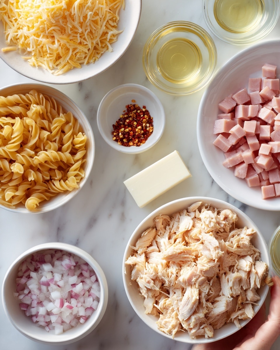 A white bowl holds shredded cooked chicken with light brown and white pieces. Next to it is a smaller white bowl with pink diced ham cubes. Another bowl contains shredded cheese, soft yellow in color. There is a small white bowl of uncooked pasta, light brown and curved. Two small white bowls hold finely chopped onions and red pepper flakes. A round white plate sits empty on a white marbled background. The scene also includes small clear containers with light yellow liquids and a small rectangular white block, all neatly arranged. A woman's hand reaches toward one of the bowls. Photo taken with an iphone --ar 4:5 --v 7