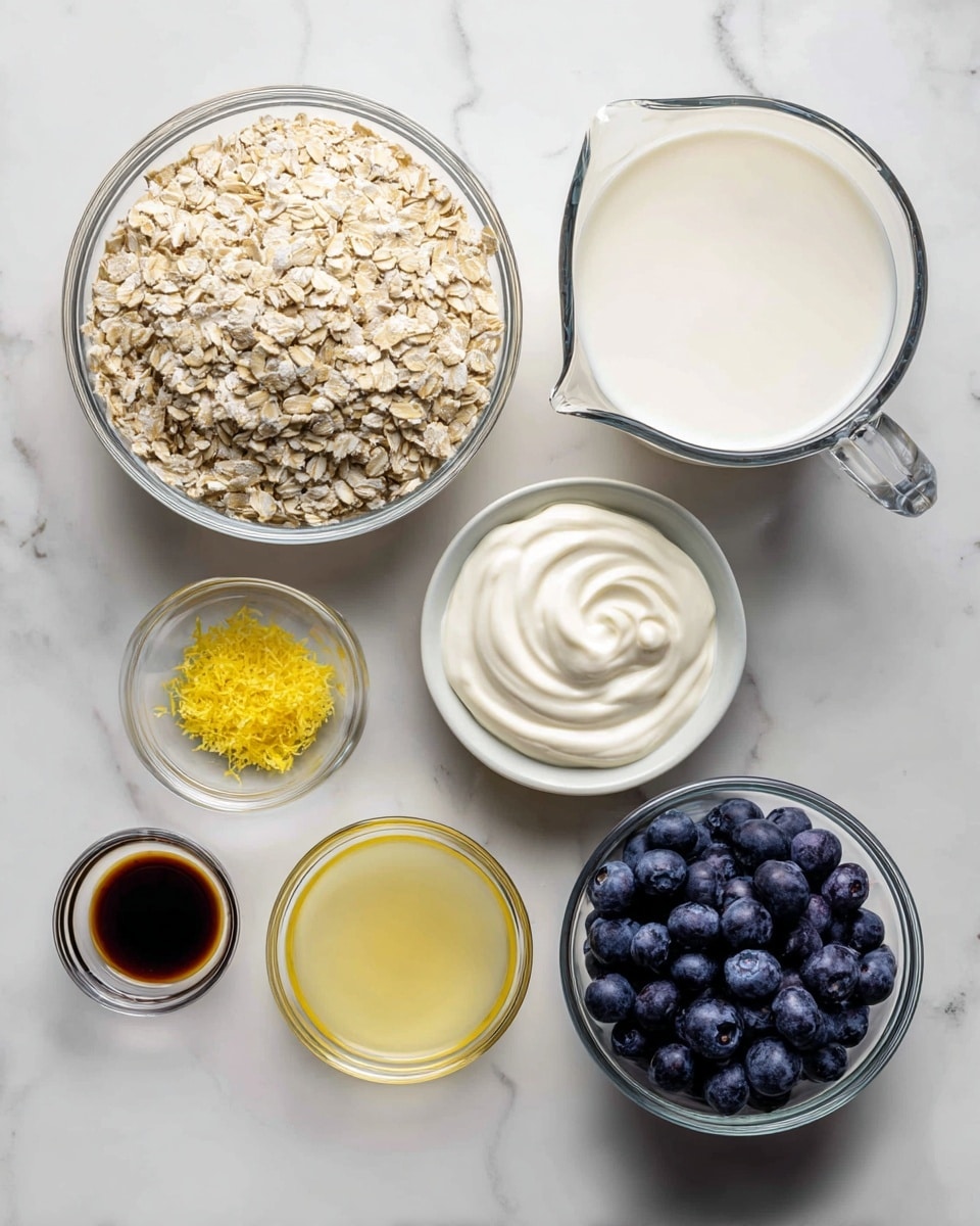 The image shows seven glass containers set on a white marbled surface. On the top left, a large clear bowl is filled with light beige rolled oats, showing a dry and flaky texture. To the right, a medium-sized clear bowl holds smooth, creamy white yogurt, with gentle swirls on the surface. A large clear measuring cup with a handle near the center back contains white milk, reflecting light softly. Below it, a small clear glass bowl holds coarse white salt. Near the center, a small clear measuring cup is filled with dark amber vanilla extract, showing a shiny liquid surface. Toward the bottom left, a tiny bowl has bright yellow lemon zest, finely grated with a textured look. Next to it, another small clear bowl contains pale yellow fresh lemon juice. On the bottom right, a medium bowl is filled with fresh blueberries, deep blue with a slightly frosted appearance. Photo taken with an iphone --ar 4:5 --v 7