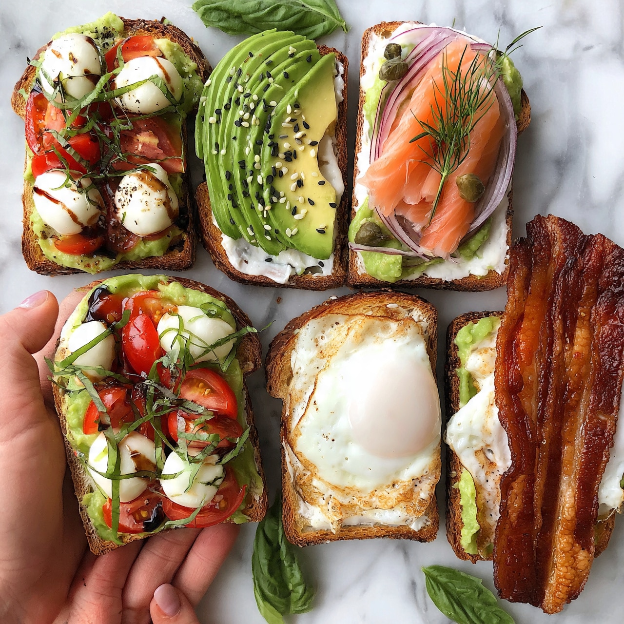 square image The image shows four slices of toasted bread with different toppings arranged on a white marbled surface. The first slice has a green avocado spread topped with white mozzarella balls and red cherry tomato halves, garnished with thin green basil strips and a drizzle of dark balsamic glaze, arranged in two layers. The second slice features thin green avocado slices neatly laid over a layer of white spread, sprinkled with black and white sesame seeds. The third slice has a white spread layer topped with green avocado spread, thin red onion slices, thin pink smoked salmon layers, and small green capers, decorated with green dill sprigs. The fourth slice shows green avocado spread with two thick crispy brown bacon strips and a white fried egg on top. A woman's hand is holding the slice with mozzarella and tomatoes, and there are some green basil leaves placed around the slices. Photo taken with an iphone --ar 4:5 --v 7