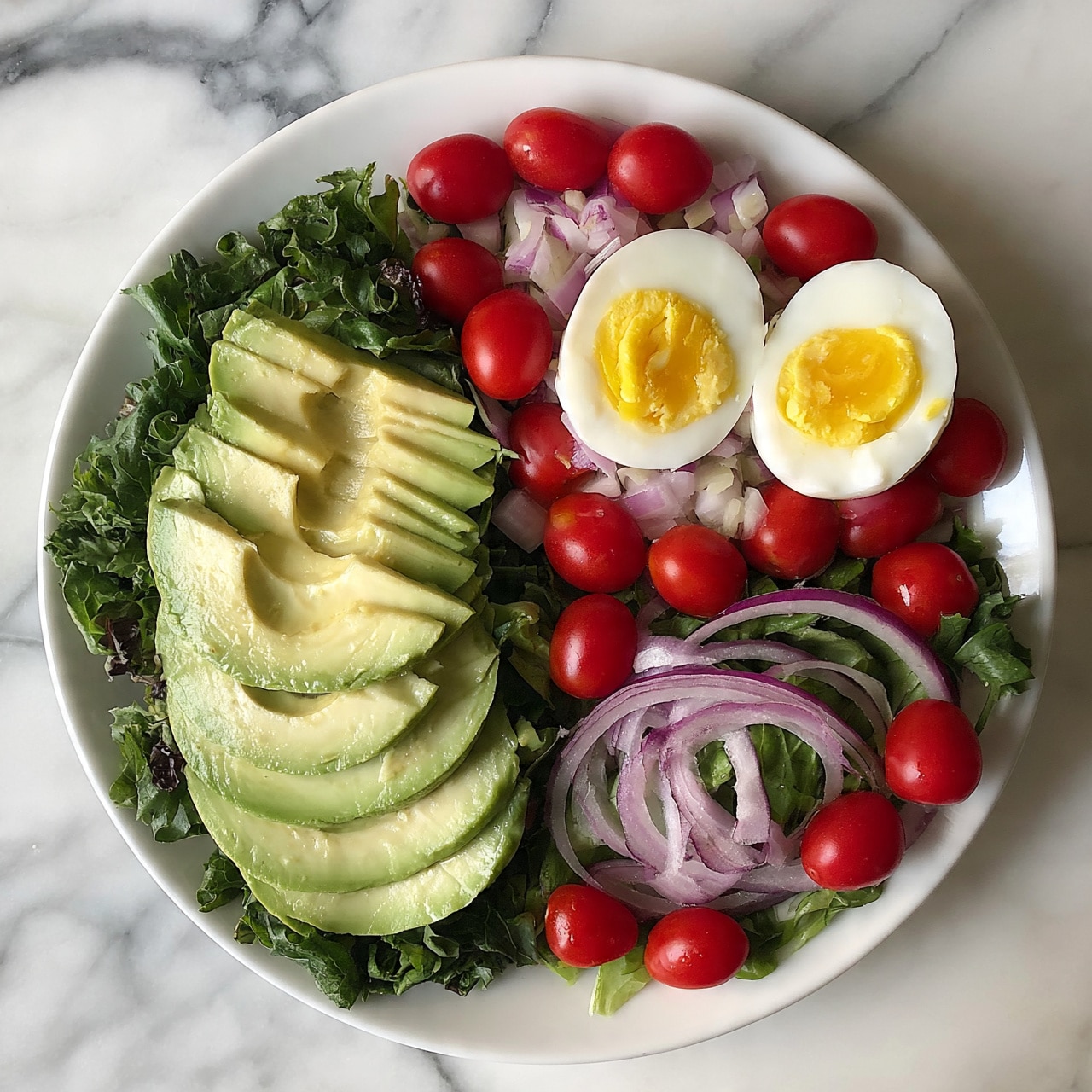square image A white plate with a fresh salad arranged in three main sections on a white marbled surface. One section has sliced avocado fanned out with a creamy texture and pale green color, placed on a bed of dark green lettuce leaves. Another section features two halves of a hard-boiled egg with yellow yolks and white edges, sitting on a mix of raw chopped vegetables with light purple onion slices and red grape tomatoes evenly scattered around. The third section includes thin slices of red onion, and more grape tomatoes spread over leafy greens. The whole dish is colorful with layers of green, red, purple, yellow, and white. photo taken with an iphone --ar 4:5 --v 7