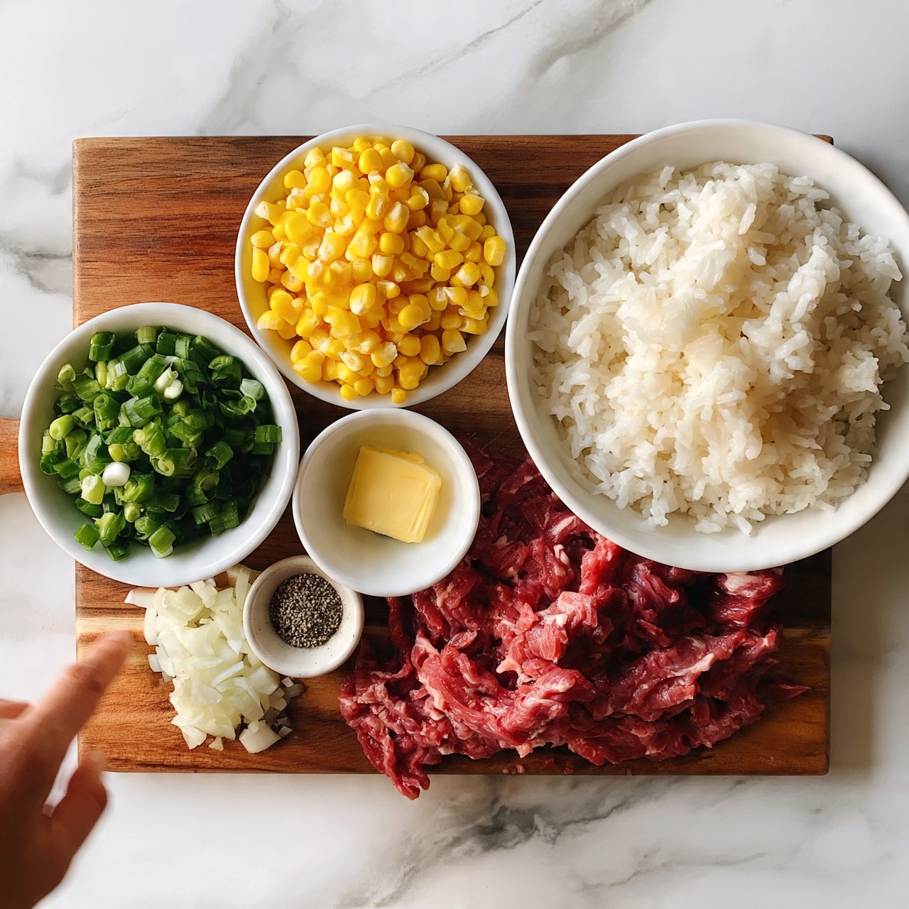 square image The image shows a wooden board on a white marbled surface, holding six white bowls and piles of ingredients. On the left in a white bowl sits chopped green onions, next to it a white bowl filled with bright yellow corn kernels. To the right is a large white bowl full of white cooked rice. Below these bowls are thin slices of raw red meat spread out, with a small pile of sliced white onions next to it. In the center is a small white bowl with a square of yellow butter, and next to it a tiny white bowl with black pepper. A woman's hand enters the frame from the left edge, pointing toward the ingredients. Photo taken with an iphone --ar 4:5 --v 7