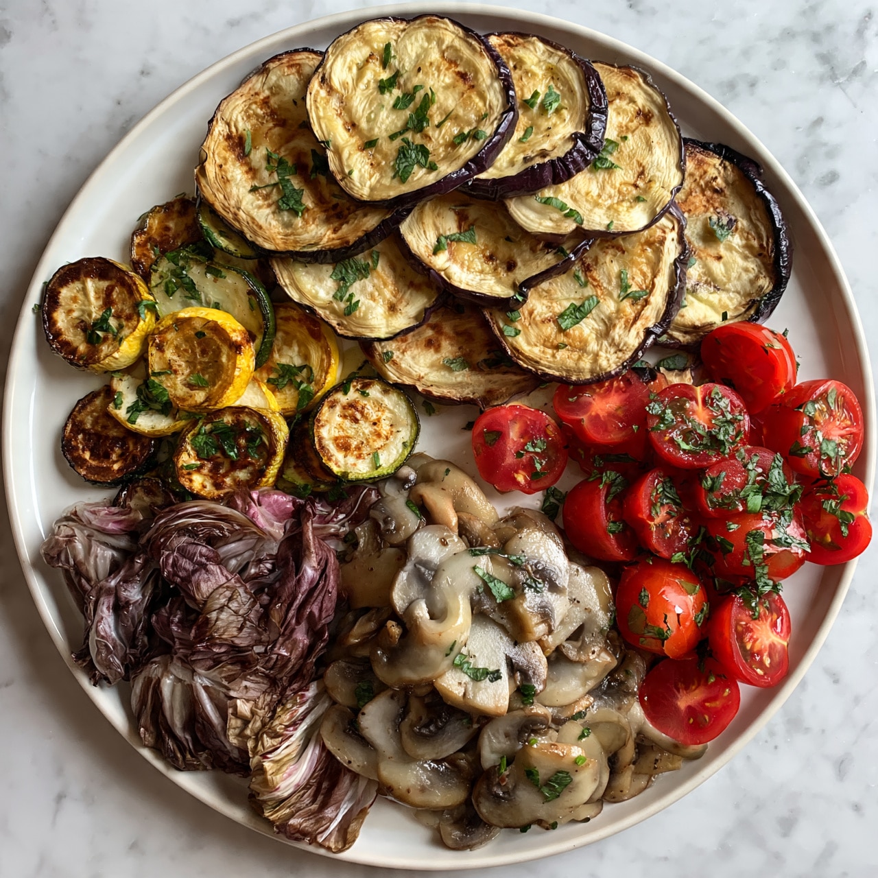 square image A round white plate with sections of food arranged by type: the top section has layers of round, grilled light brown eggplant slices with dark purple edges, lightly topped with green herb pieces; below and to the left are small browned yellow and green round zucchini slices mixed with green herbs; the lower left section shows purplish radicchio leaves; the bottom center has sautéed mushroom slices with a soft grayish-brown color and bits of green herbs; the right section has bright red halved cherry tomatoes sprinkled with green herb pieces; the plate sits on a white marbled surface. Photo taken with an iphone --ar 4:5 --v 7