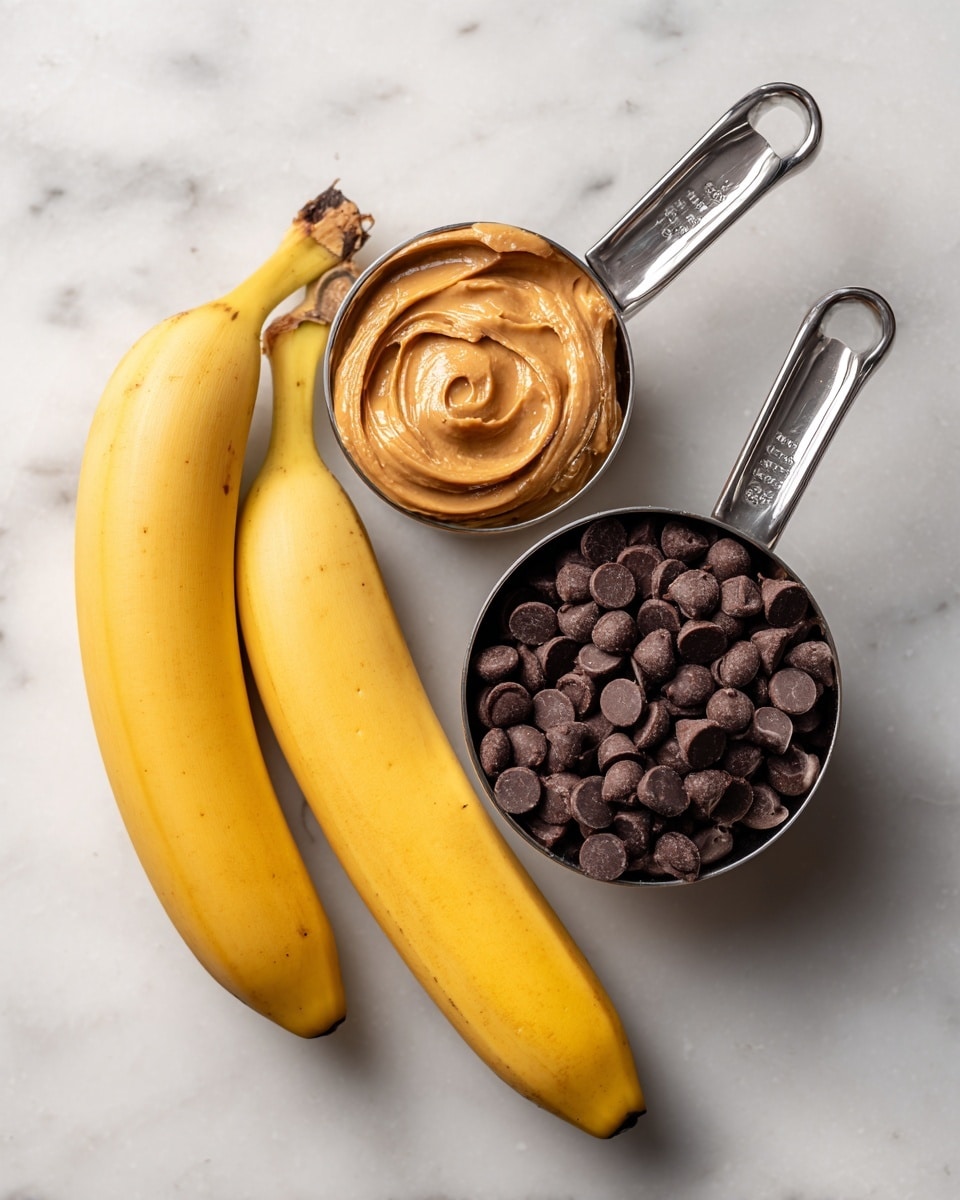 The image shows two whole yellow bananas placed side by side on a white marbled surface. Next to the bananas, there are two metal measuring cups with handles; the top cup contains light brown creamy peanut butter, and the bottom cup is filled with smooth dark brown chocolate chips. The cups and bananas are arranged neatly, with the bananas positioned horizontally and the cups placed above and below to the right of the bananas, creating a simple and clean layout. Photo taken with an iphone --ar 4:5 --v 7