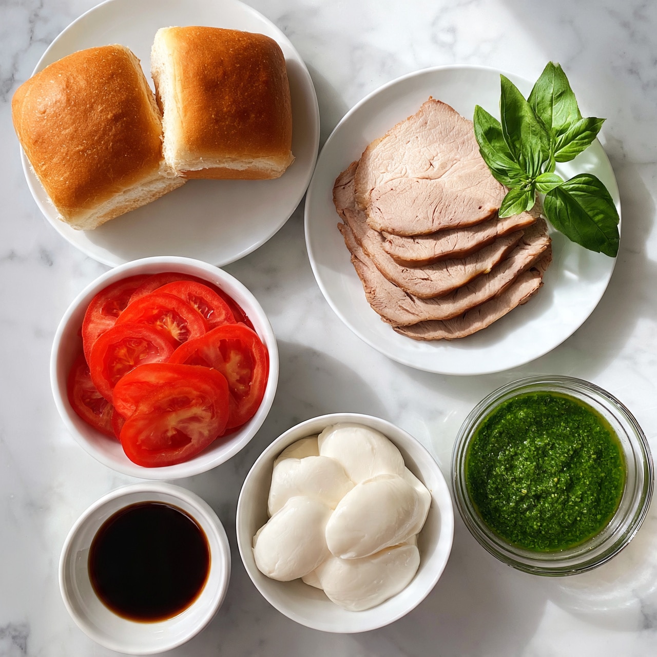 square image The image shows six white dishes arranged on a white marbled surface. One plate has two square golden-brown bread rolls with a light crust. Another plate contains several slices of cooked light brown meat, stacked neatly with a small bunch of fresh green basil leaves in a glass beside them. There's a bowl with thinly sliced red tomato rounds, bright and juicy looking. Another smaller white bowl holds soft white mozzarella cheese slices, smooth and round. A clear glass bowl contains a vibrant green pesto sauce with a slightly chunky texture. Finally, a small bowl with a dark brown balsamic vinegar adds contrast. All dishes are clean and neatly placed. Photo taken with an iphone --ar 4:5 --v 7