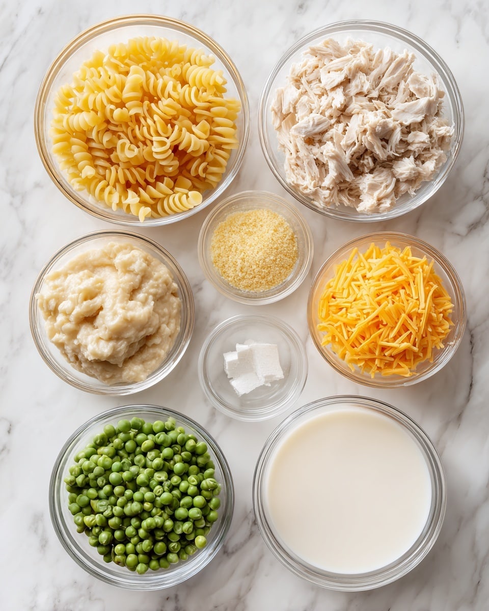 A collection of nine clear glass bowls arranged on a white marbled surface, each containing different ingredients: a large bowl of uncooked yellow pasta noodles with small twists, a large bowl of shredded light beige chicken, a medium bowl of bright green peas, a medium bowl with yellow shredded cheese, a small bowl with pale yellow liquid, a small bowl of finely ground beige powder, a small bowl of white or light cream liquid, a small bowl of light beige creamy mixture, and a tiny bowl of white salt or seasoning. The bowls vary in size and are evenly spaced, showing a neat and organized layout. photo taken with an iphone --ar 4:5 --v 7