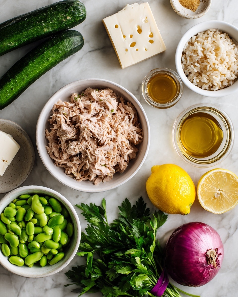 A top-down view of ingredients on a white marbled surface, including a white bowl in the center filled with shredded light brown tuna, two dark green cucumbers to the left, a block of white cheese with small holes above, and a whole bright yellow lemon on the right. Nearby are a small white bowl with a golden brown liquid and a small jar containing a similar liquid. A white bowl filled with light brown rice sits above the lemon. Below the tuna bowl, a white bowl with fresh green edamame beans, a whole red onion, and fresh green parsley bundled with a purple tie are visible. photo taken with an iphone --ar 4:5 --v 7
