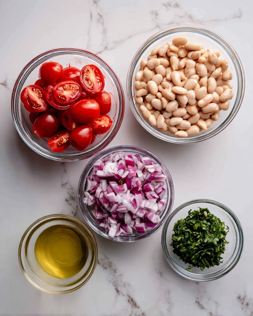 The image shows five clear glass bowls placed on a white marbled surface. The largest bowl at the top right is filled with light beige beans. Moving down to the top left, a medium bowl holds bright red cherry tomatoes sliced in half, showing their juicy interiors. Below the tomatoes, a small bowl contains finely chopped red onions with white and purple pieces mixed together. To the right of the onions is another small bowl filled with light green chopped herbs, likely cilantro or parsley. At the bottom left, a small glass bowl contains a pale yellow liquid, resembling a dressing or oil. All bowls are arranged neatly with distinct color contrasts between the beige beans, red tomatoes, purple onions, green herbs, and yellow dressing. Photo taken with an iphone --ar 4:5 --v 7