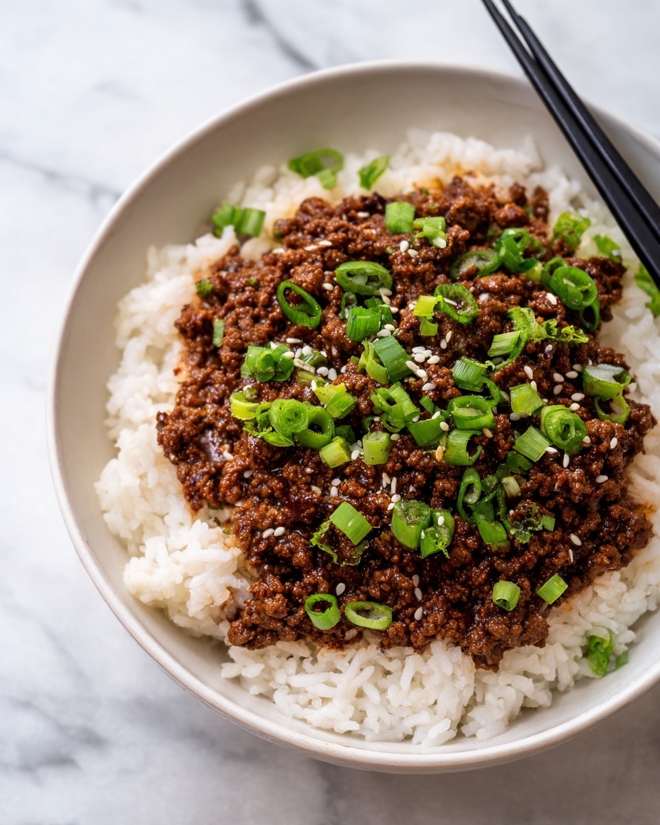 A white bowl sits on a white marbled surface, filled with two main layers. The bottom layer is plain white rice with individual grains visible, spread evenly across the bowl. On top is a thick layer of dark brown cooked ground meat with a slightly shiny texture from sauce. Scattered on the meat are bright green chopped scallions and small white sesame seeds, adding color contrast. Black chopsticks rest on the right side of the bowl, partly touching the meat layer. Photo taken with an iphone --ar 4:5 --v 7