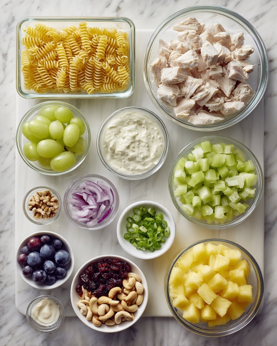 The image shows various ingredients for a dish arranged on a white marbled surface. In the center right is a clear glass measuring cup filled with chopped white chicken pieces. Surrounding it are small white bowls and glass containers holding different ingredients. From top left and moving clockwise: a rectangular glass container with yellow spiral pasta, a small glass bowl with green sliced grapes, a small glass bowl with light green chopped celery, a small round white bowl filled with a creamy white sauce, a small white bowl with chopped green onions, a small glass bowl with halved purple grapes, a small glass bowl with mixed cashews and nuts, a round glass bowl with bright yellow pineapple chunks, a small white bowl with dried red cranberries, and a small white bowl with white mayonnaise or similar sauce. The colors range from yellow, green, red, purple, and white, all displayed neatly without overlapping. Photo taken with an iphone --ar 4:5 --v 7