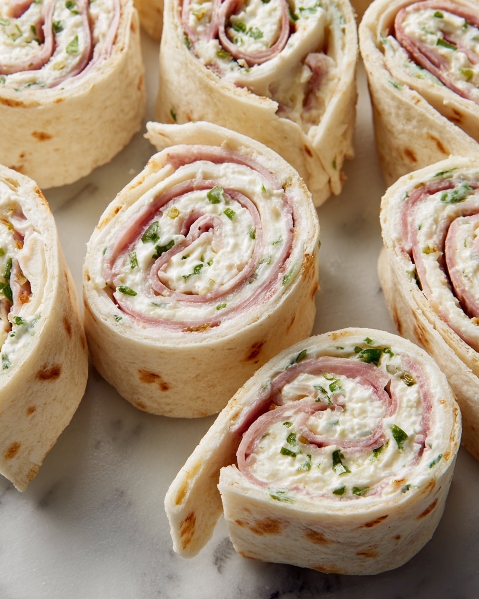 The image shows several tortilla pinwheel rolls arranged closely on a white marbled surface. Each pinwheel has about three visible layers: a light beige flour tortilla rolled around a creamy white layer mixed with small green herb bits, and a thin layer of pinkish sliced meat inside. The pinwheels are cut into bite-sized, round pieces revealing the spiral pattern of the layers inside. The texture of the tortilla looks soft and slightly toasted with small browned spots. The overall colors are pale beige, soft pink, white, and green small specks. photo taken with an iphone --ar 4:5 --v 7
