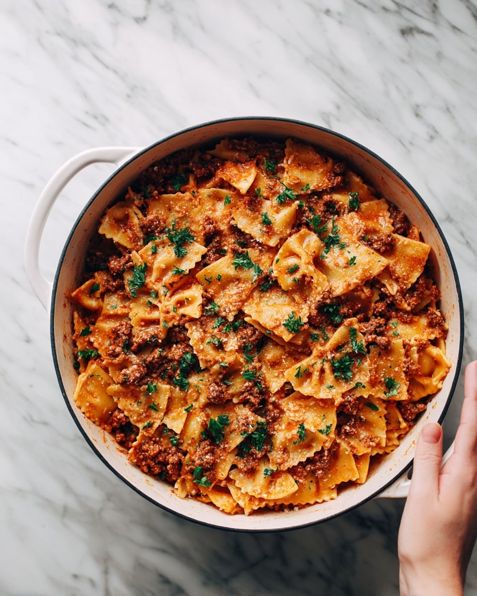 The image shows a round white cooking pot filled with a layered pasta dish. The bottom and middle layers are thick pasta sheets in a light beige color, mixed with chunks of browned meat and a rich orange-red sauce, creating a textured and slightly chunky look. Fresh green parsley is sprinkled evenly on top, adding contrast and brightness. The pot is placed on a white marbled surface, and a woman's hand is reaching towards the pot from the right side. photo taken with an iphone --ar 4:5 --v 7