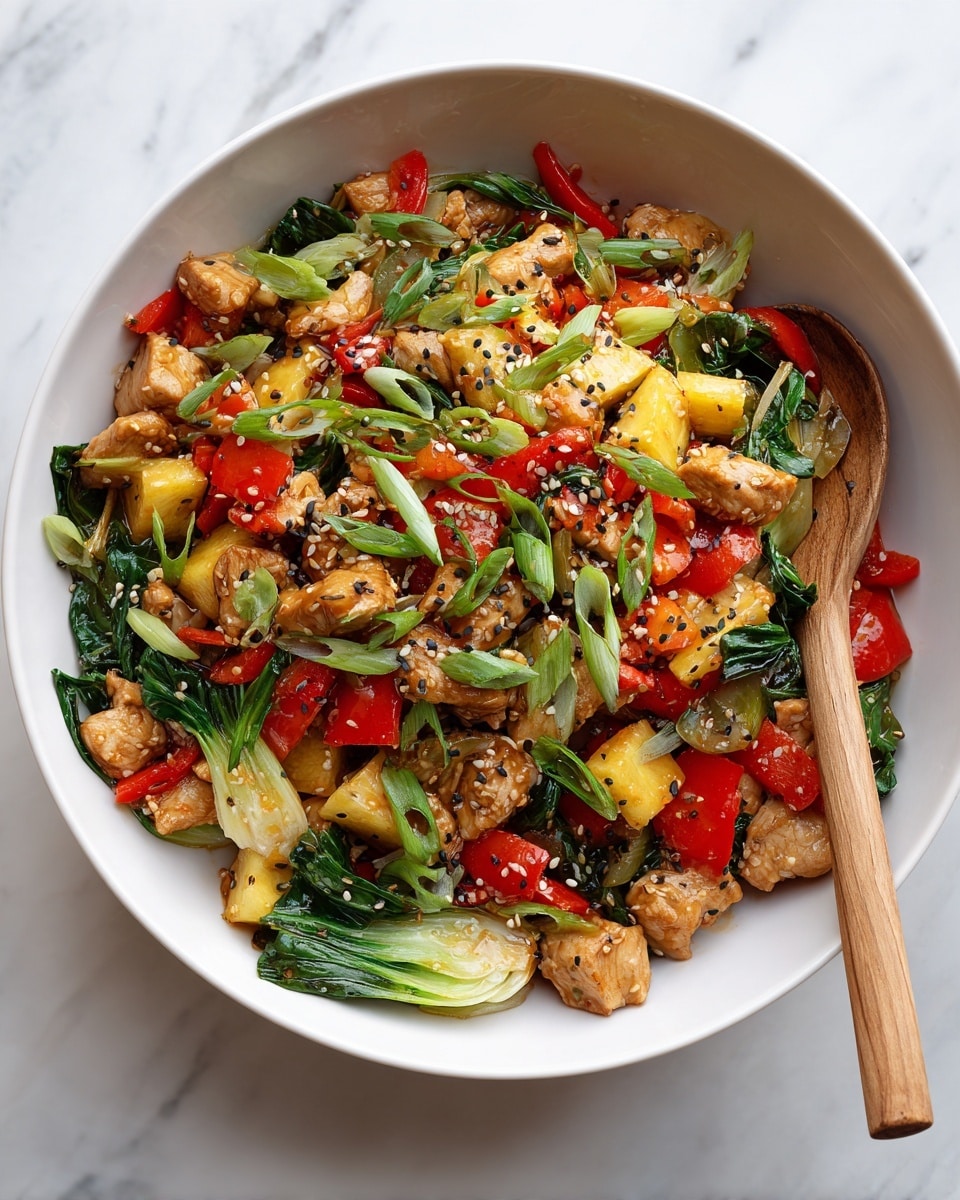 A white bowl filled with a colorful stir-fry dish sits on a white marbled surface. The dish has multiple layers including small pieces of cooked chicken that are light brown with a slightly crispy texture, bright red bell pepper chunks, yellow pineapple cubes, and green bok choy leaves with a fresh, leafy texture. There are thin slices of green onion scattered on top along with small black and white sesame seeds. A wooden spoon rests inside the bowl, showing the mixture clearly. Photo taken with an iphone --ar 4:5 --v 7