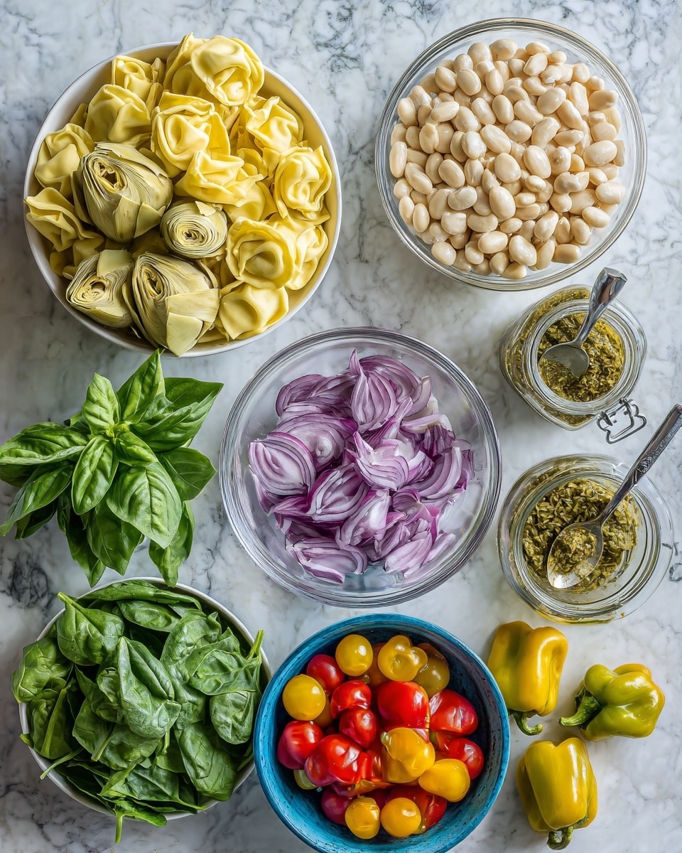 The image shows a spread of fresh and colorful ingredients on a white marbled surface. At the top center is a white bowl filled with quartered light yellow artichokes, next to a clear glass bowl of pale beige beans. Below and to the left is a pile of uncooked yellow tortellini pasta that fills much of the area. A bunch of green fresh basil leaves is placed to the left of the pasta, and to the bottom left is a white bowl filled with vibrant green spinach leaves. Toward the bottom center, there is a smaller white bowl containing thinly sliced purple-red onions. To the right side, a small blue container holds bright red and yellow cherry tomatoes on their green stems scattered slightly outside the container. Near the bottom left corner, yellow-green pepperoncini peppers sit in a small clear bowl. At the top right, an open jar with green seasoning and a silver spoon is visible. The whole arrangement is on the white marbled surface. photo taken with an iphone --ar 4:5 --v 7