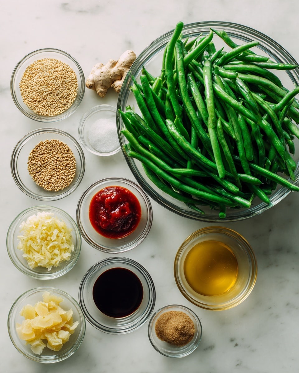 A large clear glass bowl filled with fresh green beans takes up the right side of the image, showing the bright green color and smooth texture of the beans. On the left side, eight small clear glass bowls are arranged on a white marbled surface. The bowls hold different ingredients: light brown sesame seeds, minced pale yellow garlic, a dark brown liquid sauce, bright red sauce, a light golden liquid, brown sugar, a small white powder, and grated ginger. The arrangement is neat and clean, highlighting the fresh and varied ingredients with natural lighting. Photo taken with an iphone --ar 4:5 --v 7