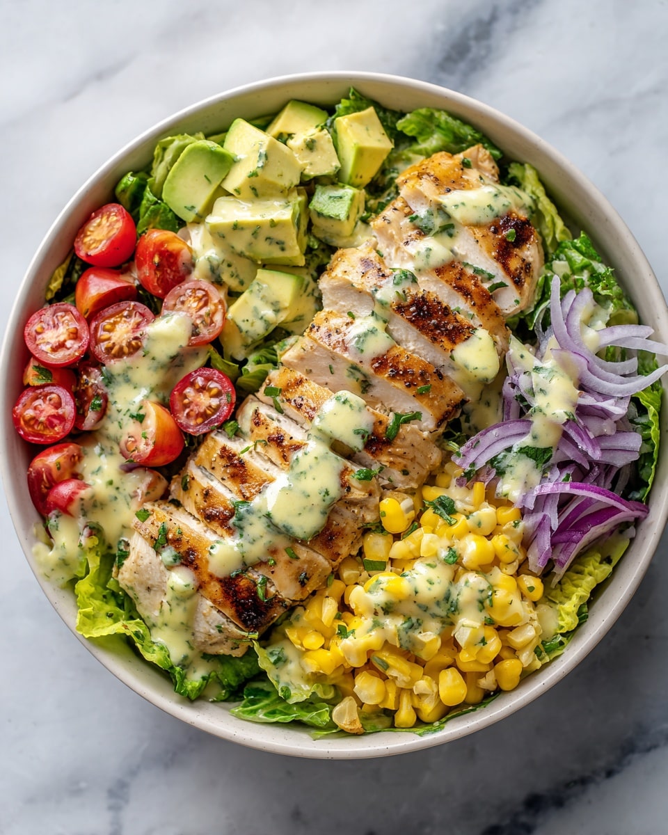 This image shows a fresh salad served on a white plate with a white marbled surface underneath. The base layer is bright green lettuce leaves, topped with slices of grilled light golden brown chicken layered in the center. Around the chicken, there are small bright yellow corn pieces, halved red cherry tomatoes, light green avocado chunks, and thin slices of purple onion scattered evenly. The entire dish is drizzled with a creamy light yellow-green dressing that has small green herbs mixed in, adding a fresh and colorful texture. Photo taken with an iphone --ar 4:5 --v 7